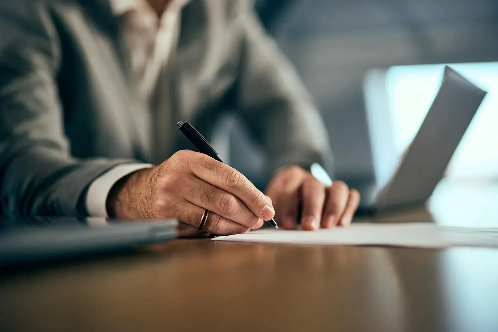 Professional notary signing a document at a tidy office desk